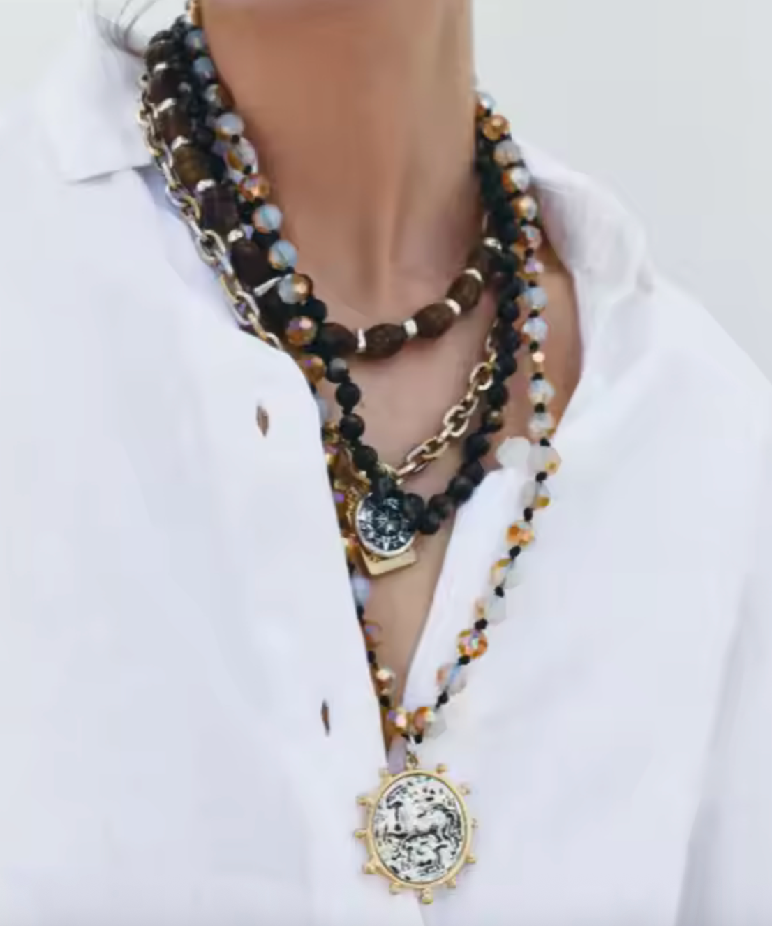 Layered necklace with mixed materials worn by woman – gold, silver, and beaded chains