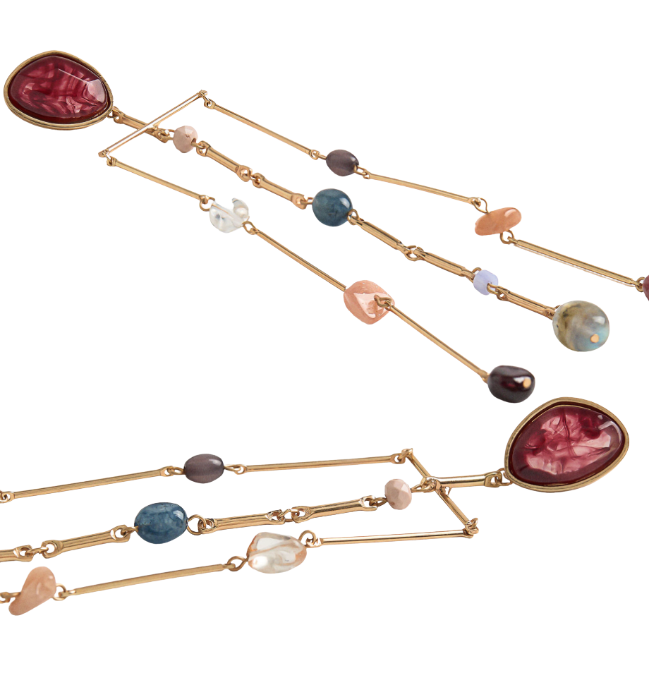 Gold necklaces with multicolored gemstones on a white background