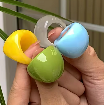 Colorful acrylic rings held in a hand with a neutral background