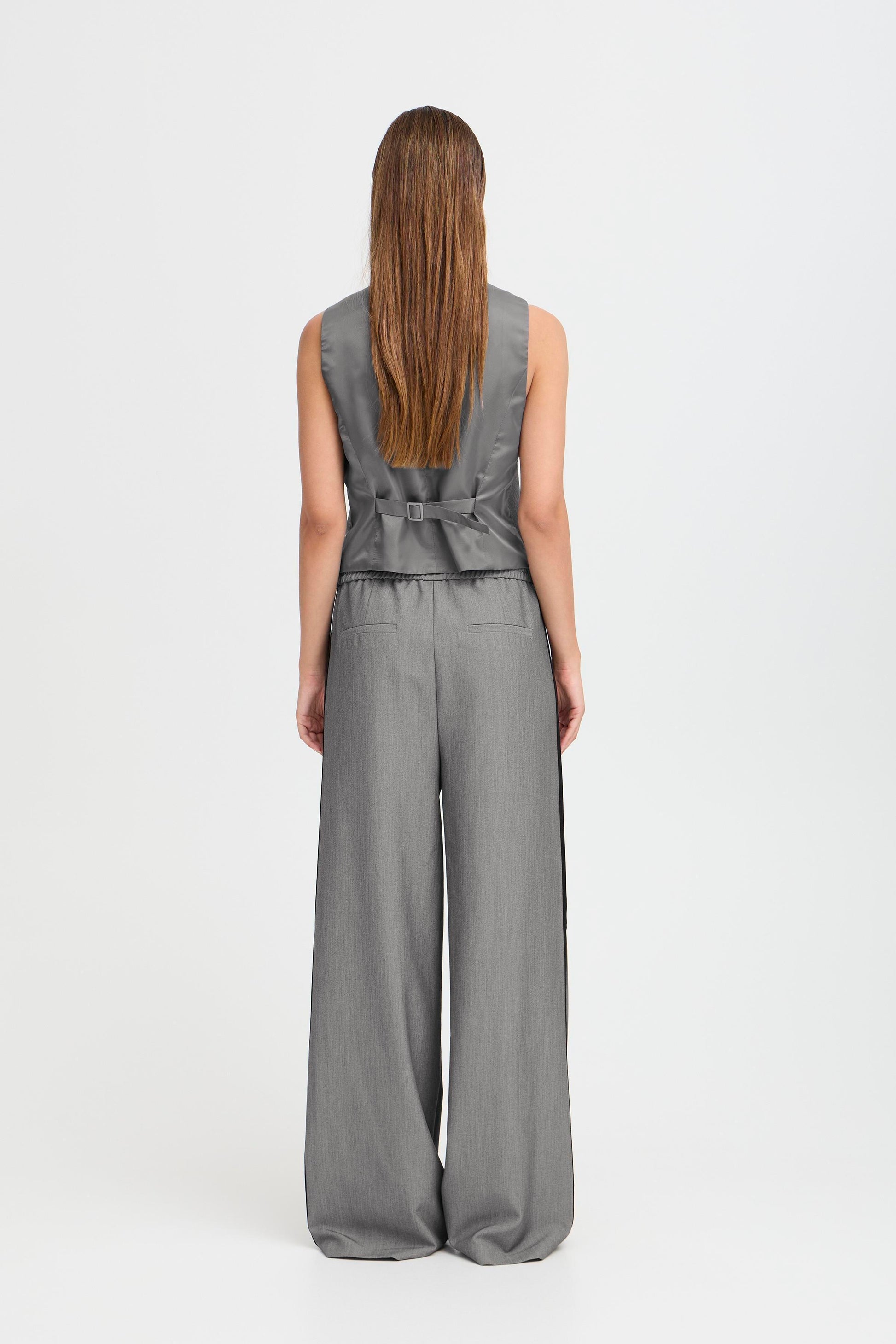 Woman wearing a gray suit with vest and wide leg pant 
