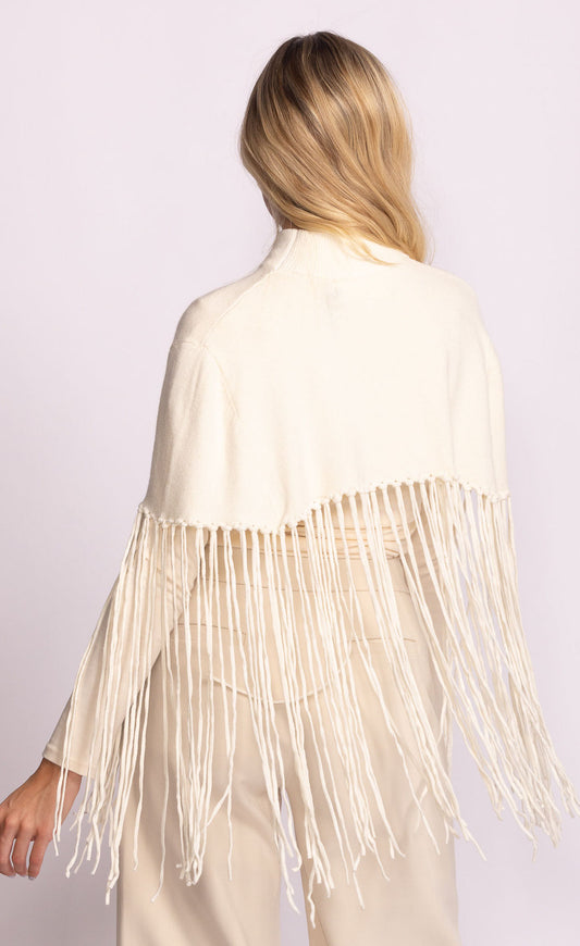 Woman wearing a beige fringe jacket on a light purple background