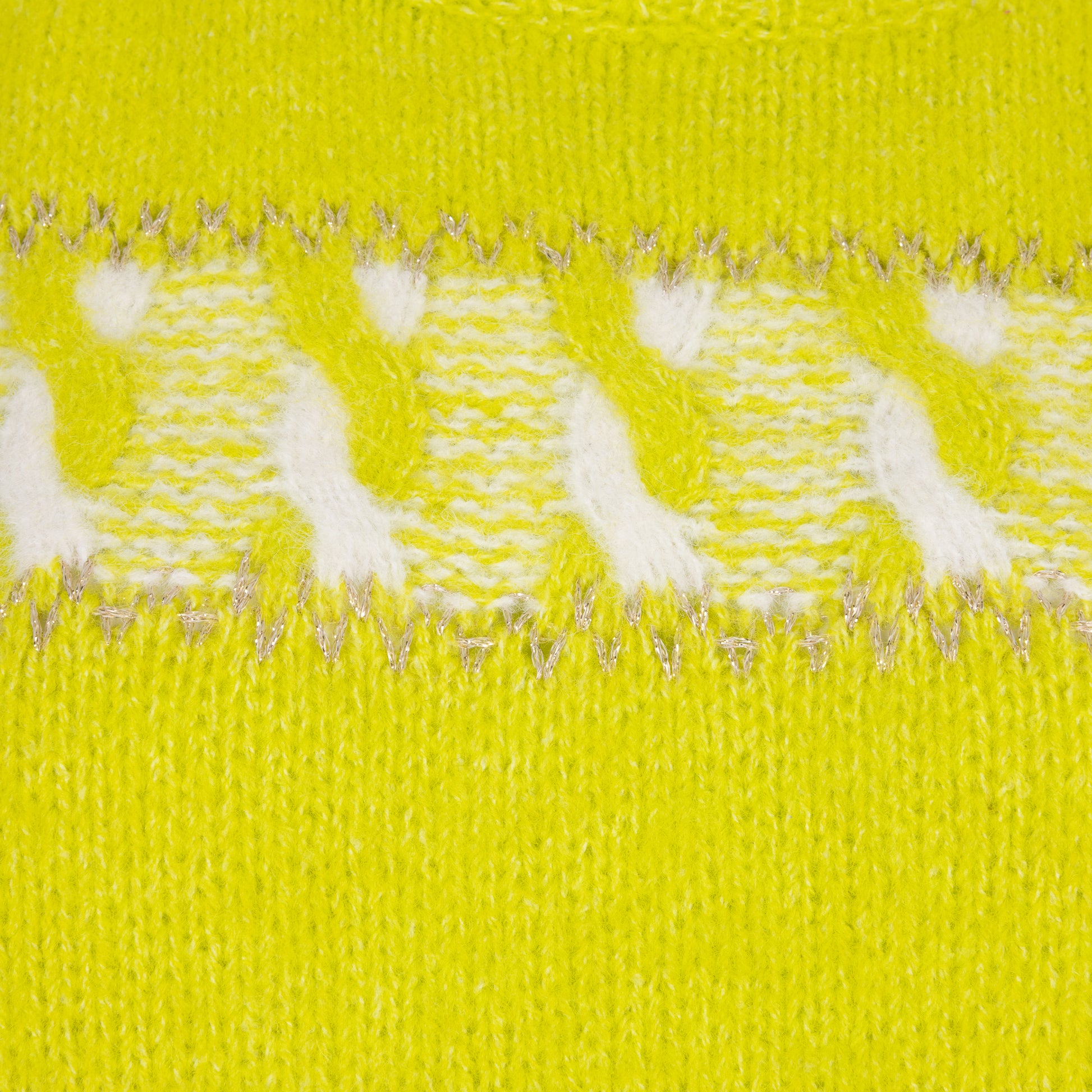 Close-up of a yellow fabric with white polka dots and silver thread