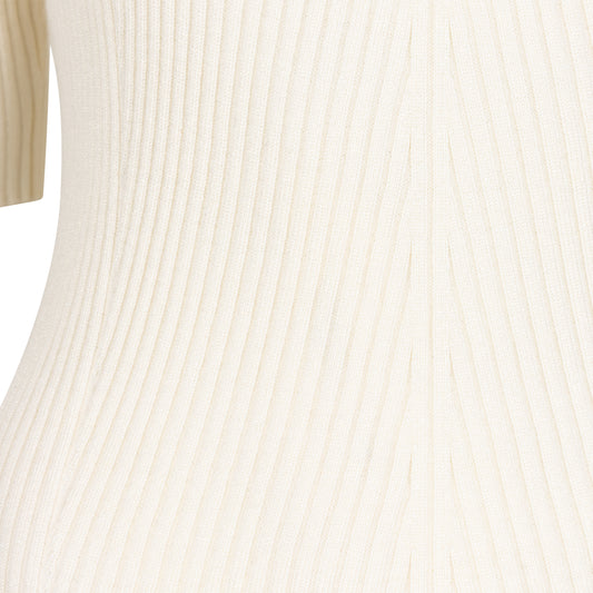 Close-up of a beige ribbed sweater with a blurred background