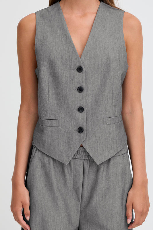 Gray vest with black buttons worn by a woman 